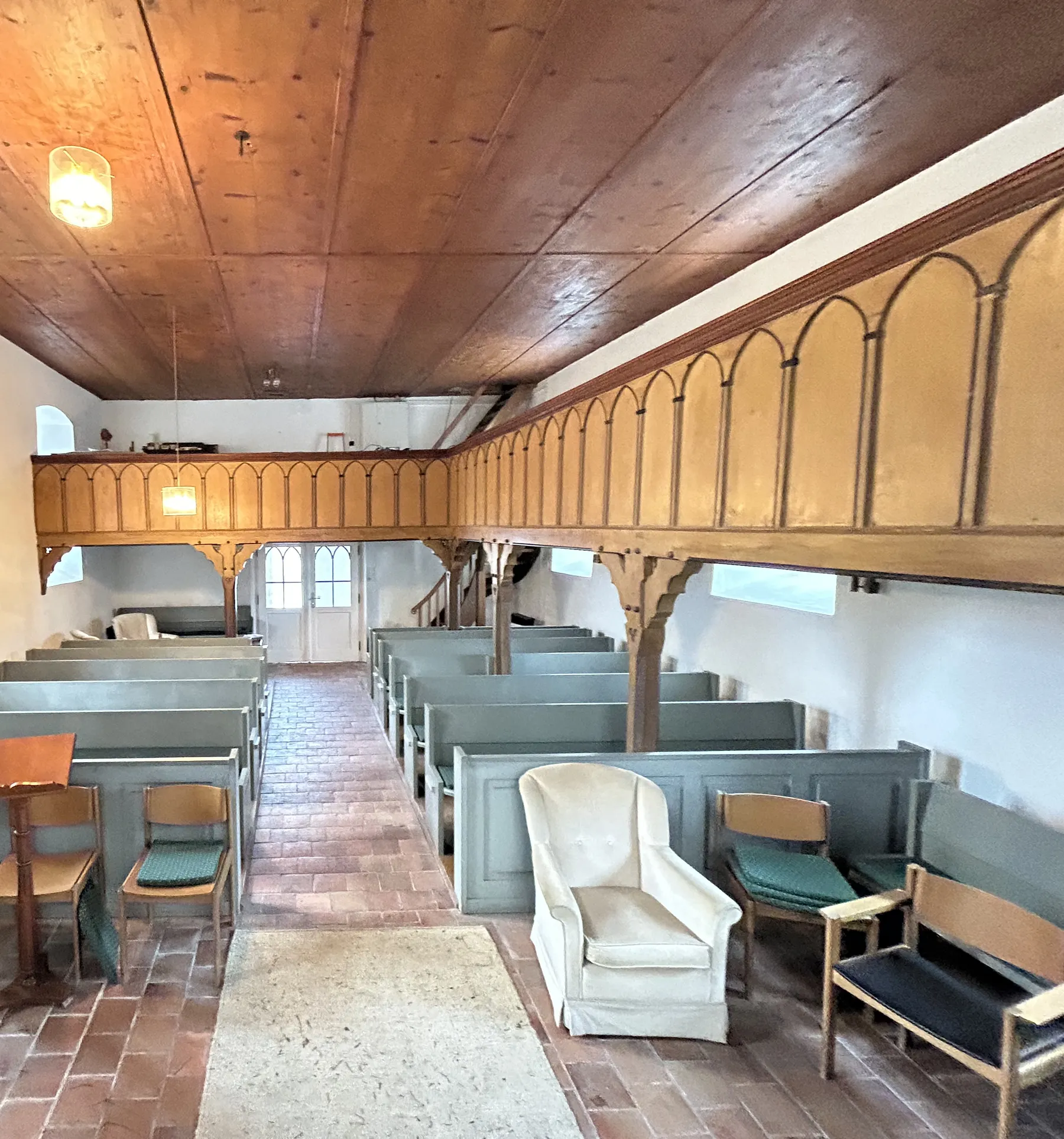 Innenraum der Kirche mit Holzdecke, Empore und Kirchenbänken vor dem Umbau